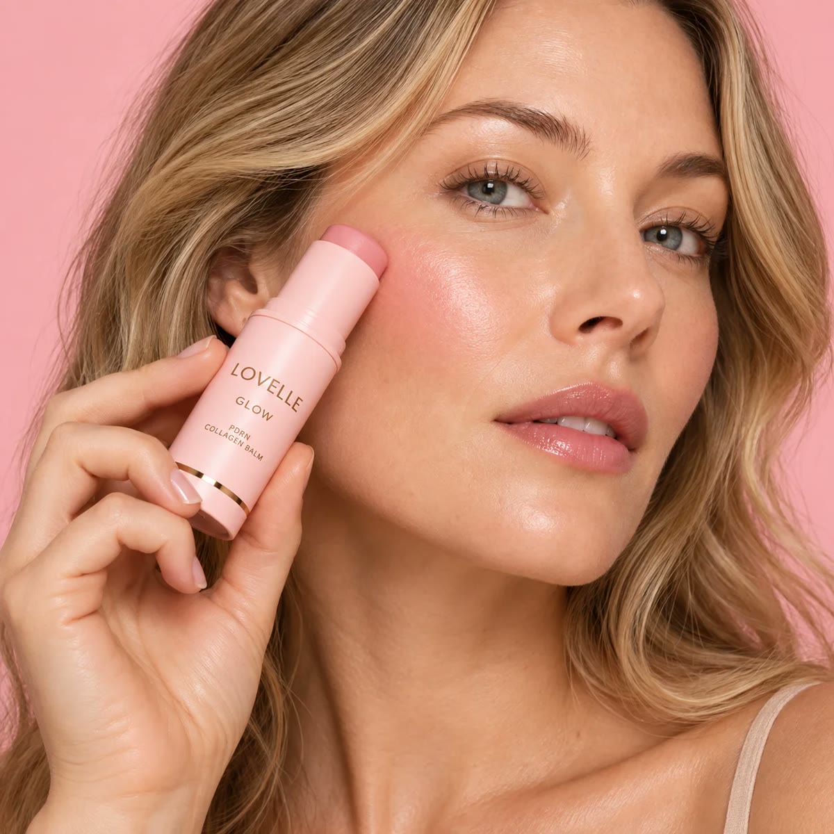 Kvinna applicerar Lovelle Glow på kinden